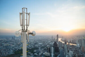5G telecommunication tower antenna overlooking a city skyline
